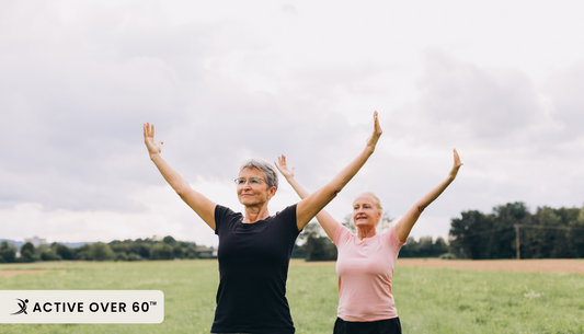 two women standing in a field with their arms up