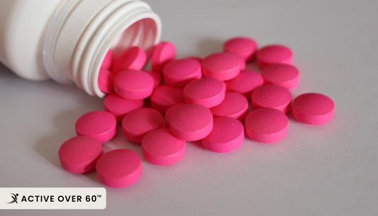 pink pills spilling out of a white bottle
