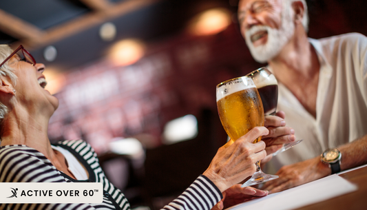 A man and woman toasting beer at a bar