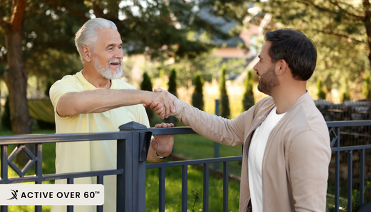 two people shaking hands in front of a fence