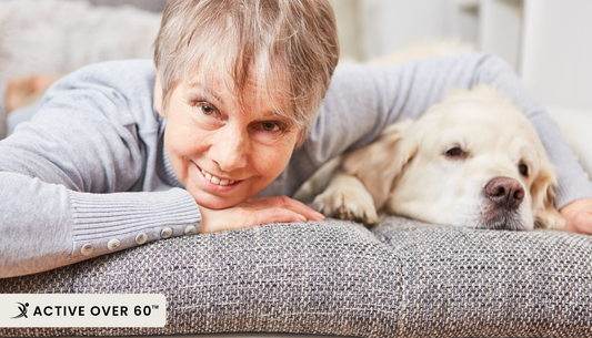 A person laying on a couch with their dog