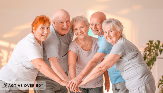 Happy, active seniors exercising together in a well-lit indoor fitness room, engaging in low-impact movements and enjoying an active lifestyle.