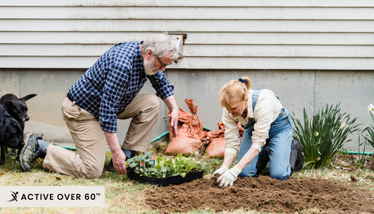 Two people are planting plants in the yard