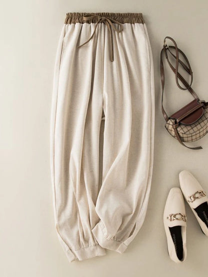 Beige pants with a handbag and shoes on a light background