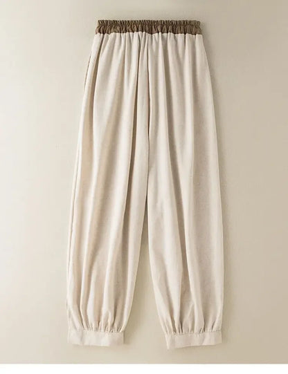 Beige pants with a brown waistband on a beige background