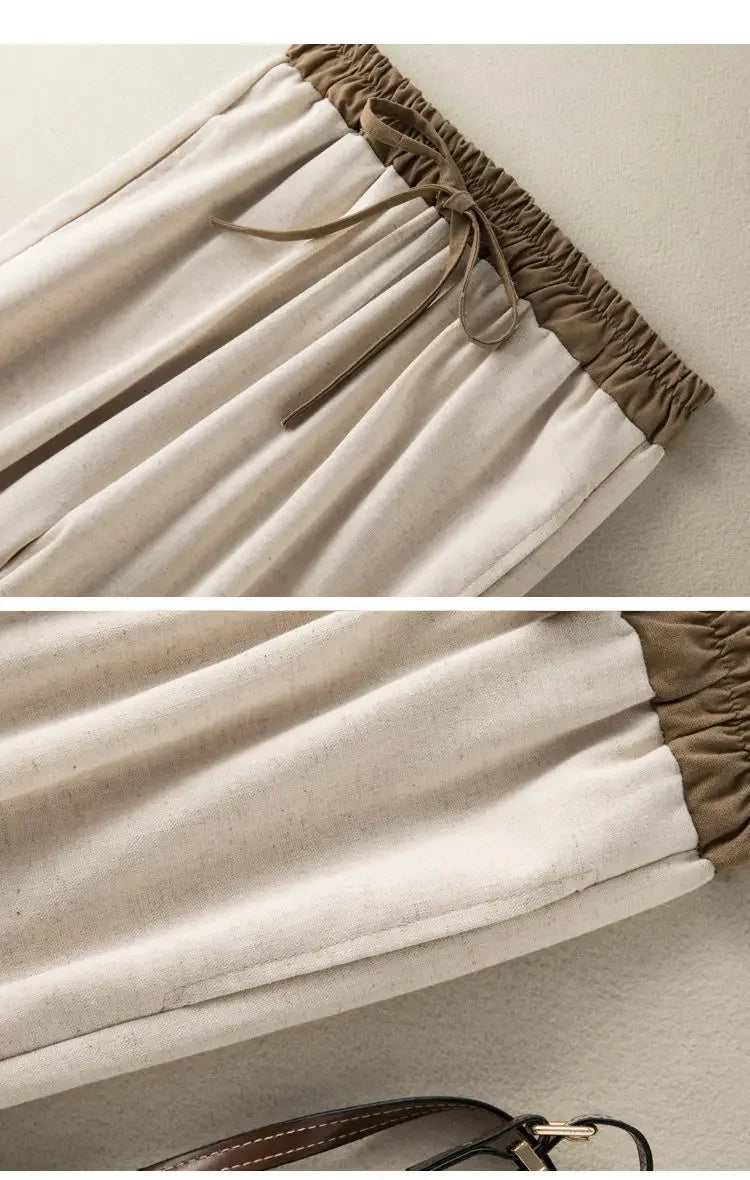 Close-up of beige pants with brown waistband and hem on a neutral background