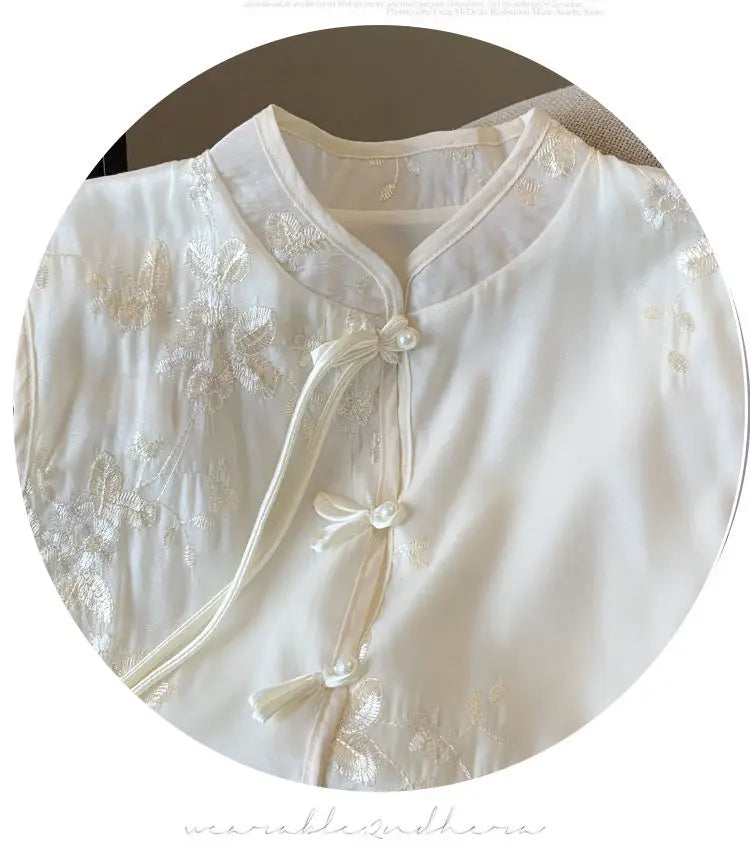 Sleeveless stand collar blouse with button front and floral embroidery, ideal for warm-weather walks or casual gatherings.