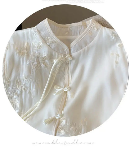 Sleeveless stand collar blouse with button front and floral embroidery, ideal for warm-weather walks or casual gatherings.