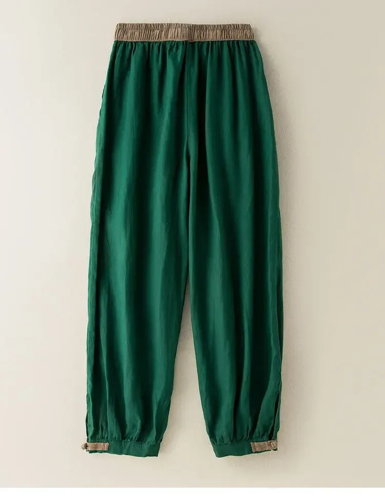 Green pants with brown trim on a beige background