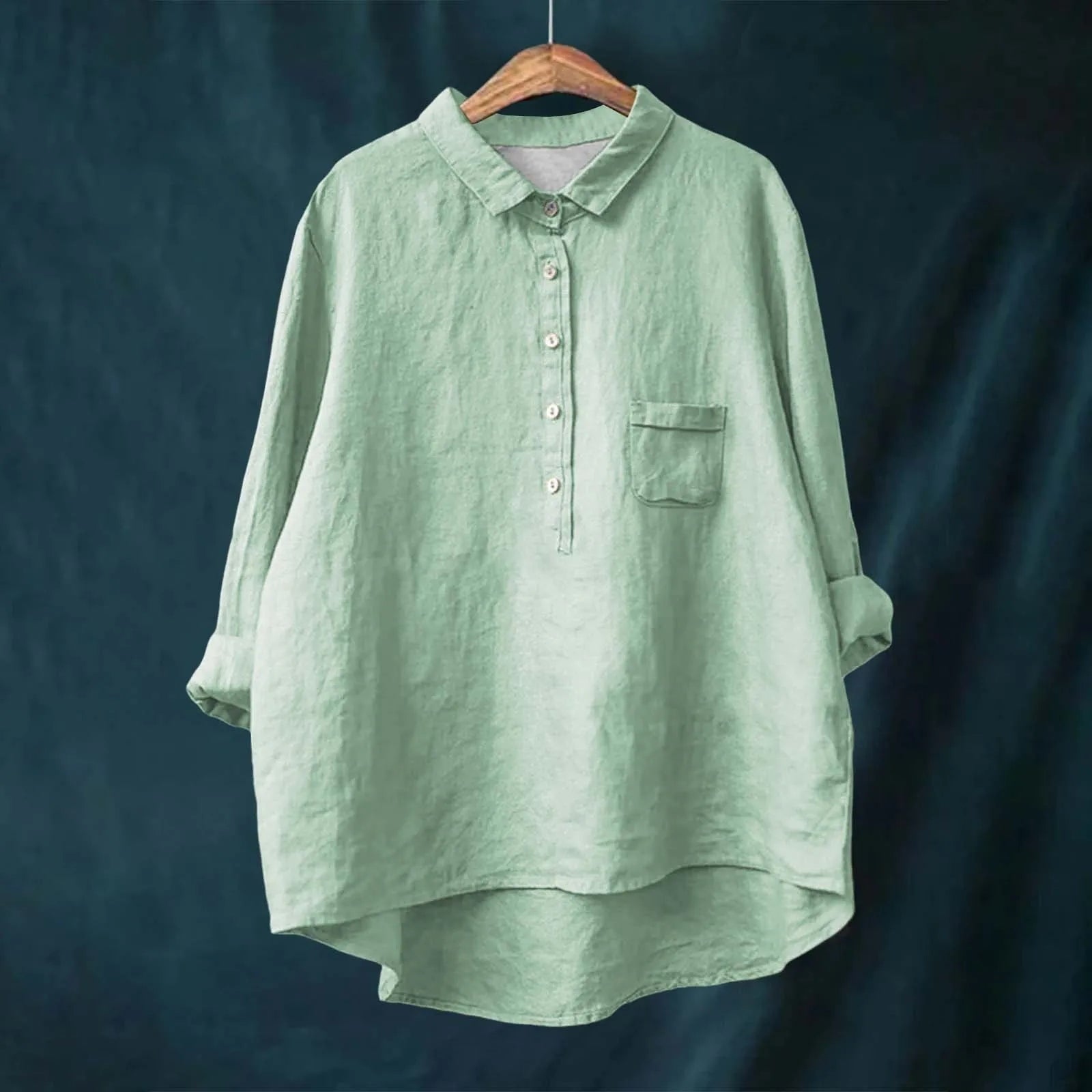 Green shirt on a hanger against a dark background