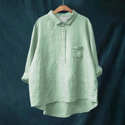 Green shirt on a hanger against a dark background