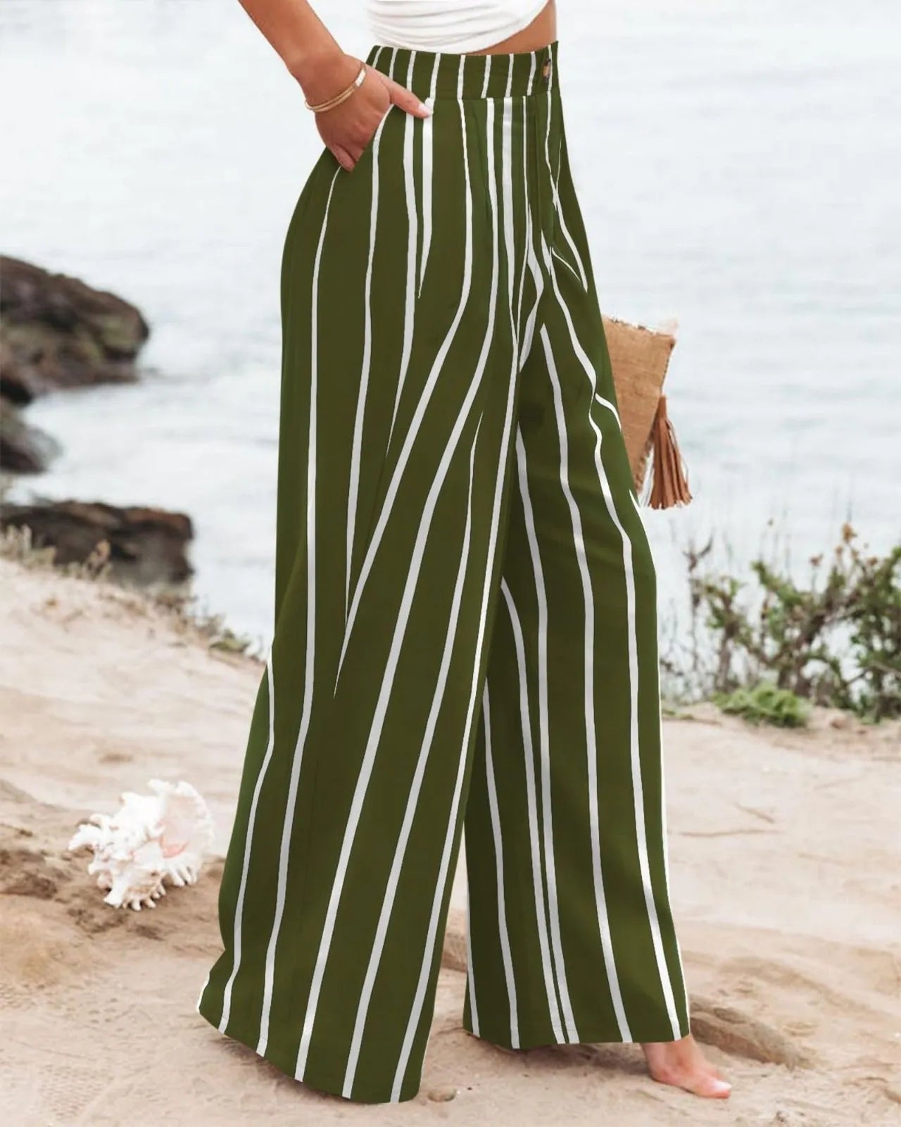 Green and white striped pants worn by a person on a beach.