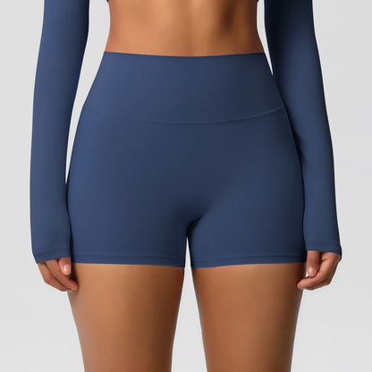 A pair of high-waist navy blue yoga shorts, worn with a matching long-sleeve top and white sneakers, suitable for fitness support during workouts or daily activities.