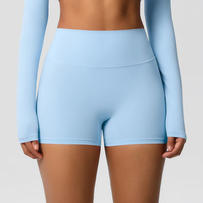 A pair of high-waist sky blue yoga shorts, worn with a matching long-sleeve top and white sneakers, suitable for fitness support during workouts or daily activities.