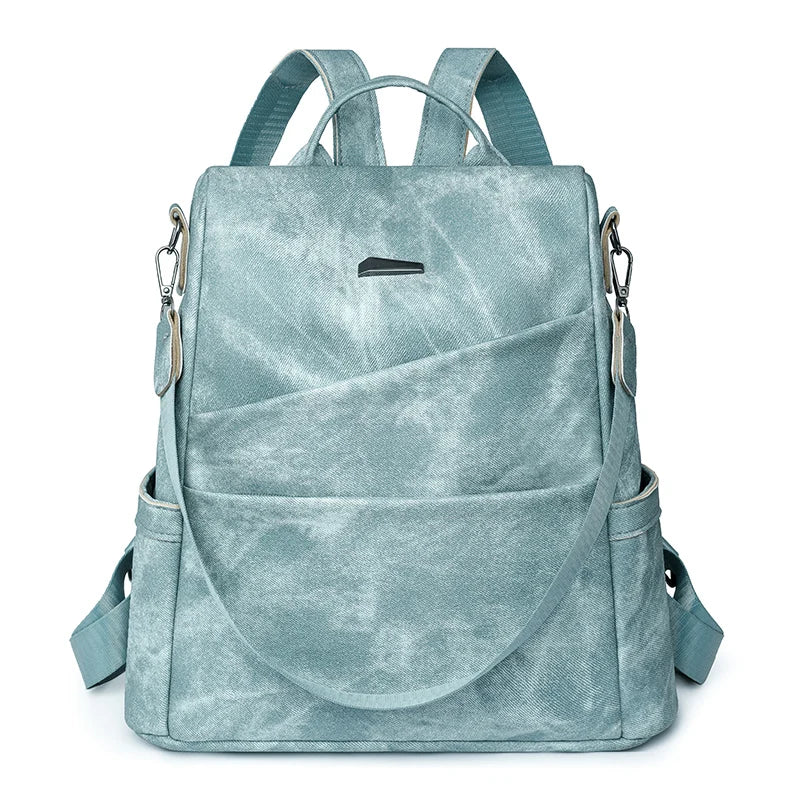 A green leather backpack for women with multiple compartments and an adjustable shoulder strap.