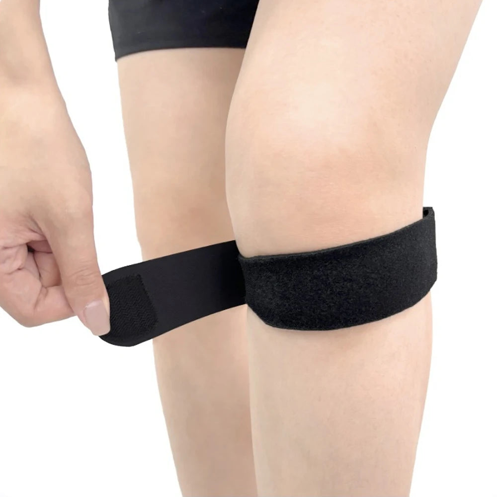 Person wearing a black knee brace on one knee with a plain background