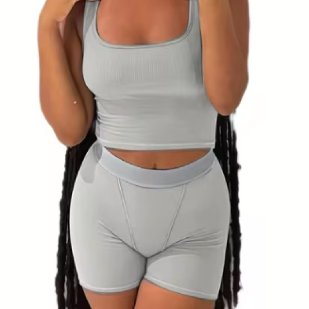 A woman wearing a white ribbed knit crop tank top and matching high-waisted leggings.