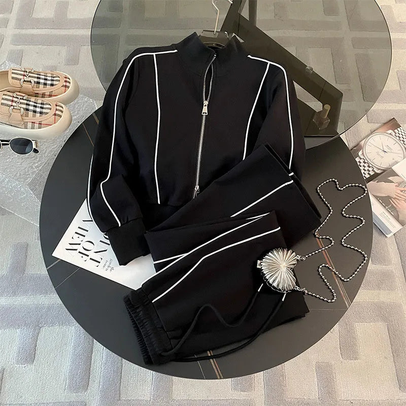 A Striped Contrast Sweatshirt and Pants Set for adults, displayed on a circular platform with a casual, sporty appearance in black color