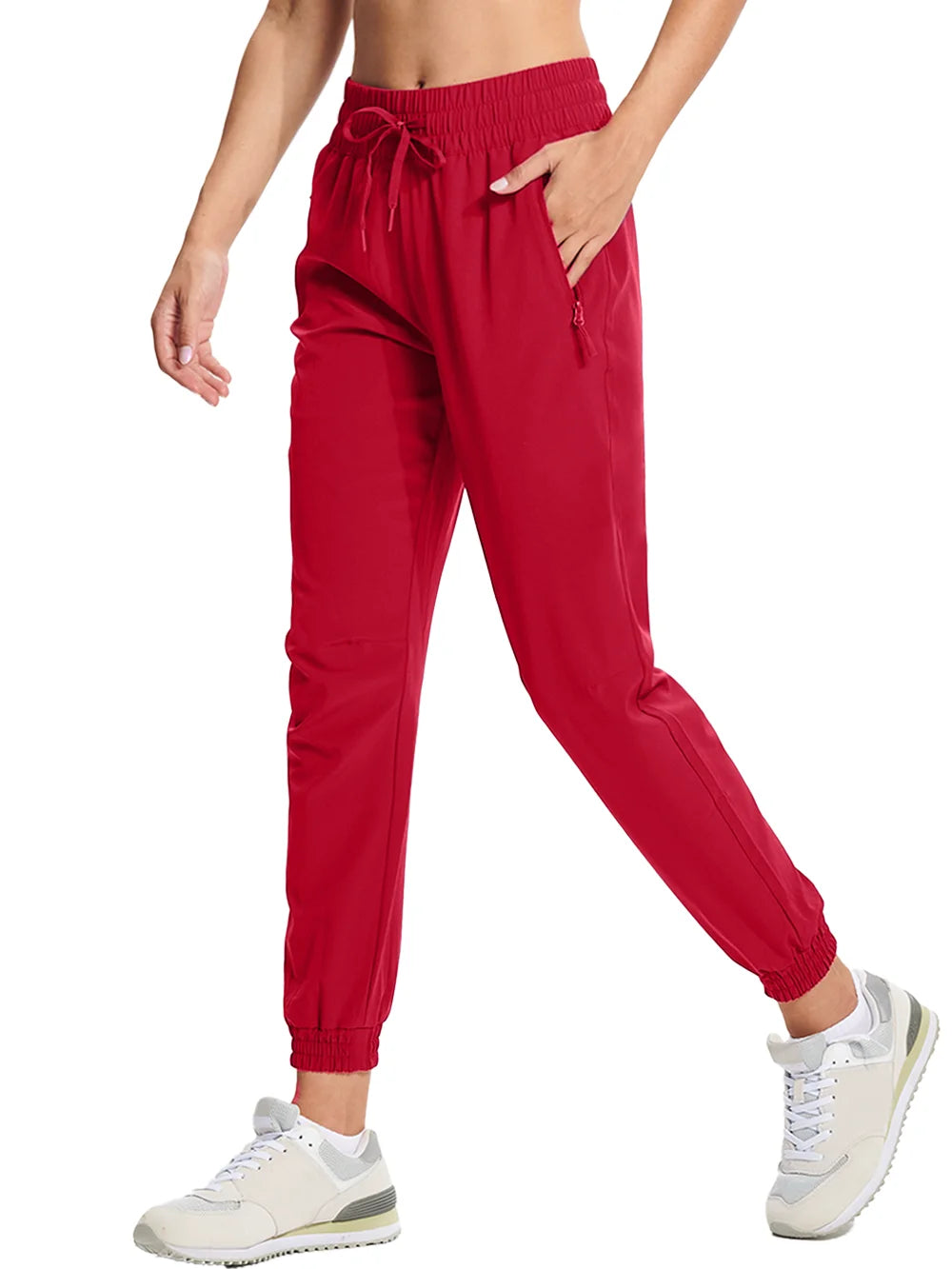 A pair of tomato red athletic pants with an elastic waistband and drawstring, featuring side pockets and a full-length design.