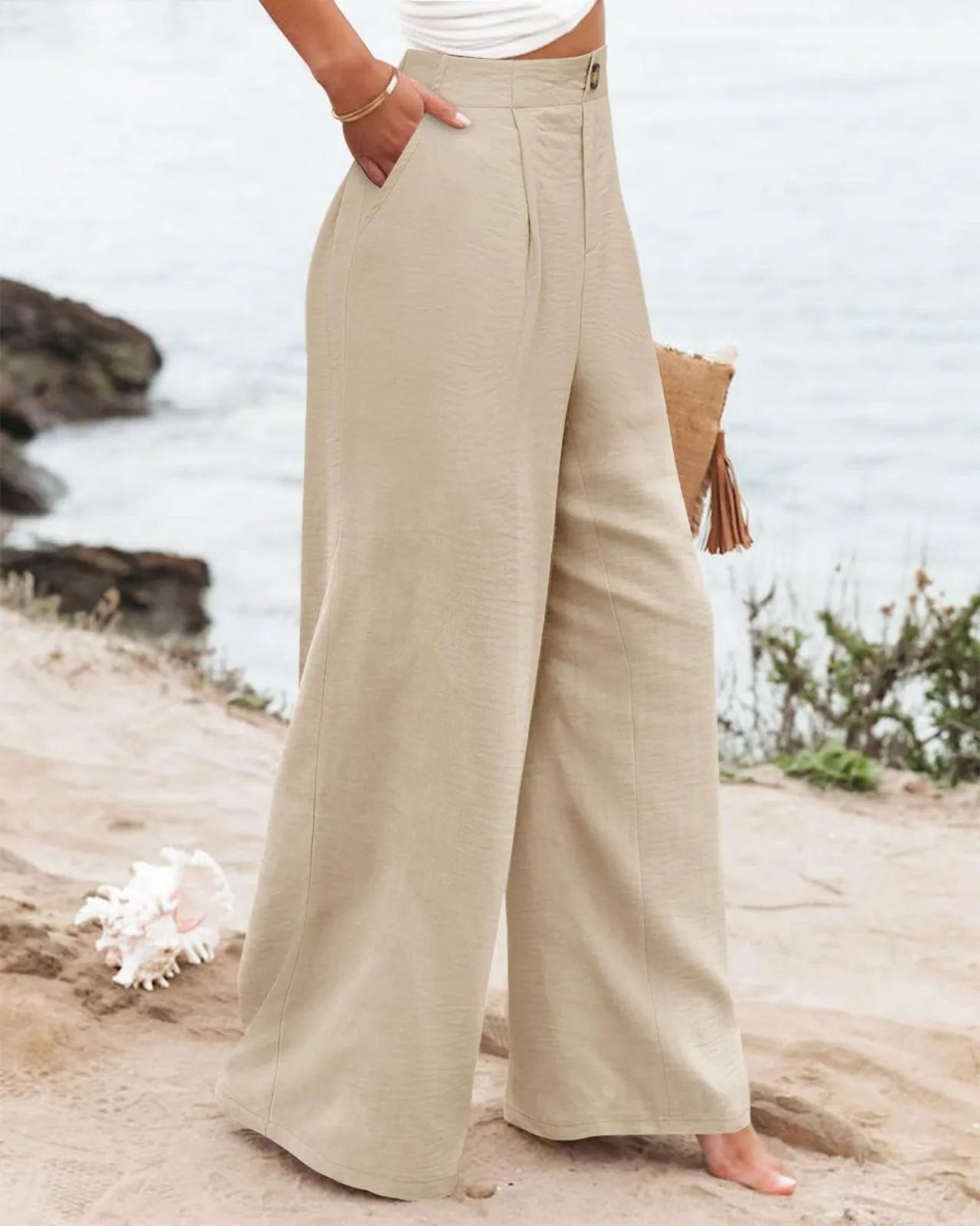 Person wearing beige wide-leg pants standing on a beach.
