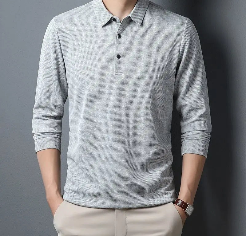 Man wearing a light gray long-sleeve polo shirt against a dark background