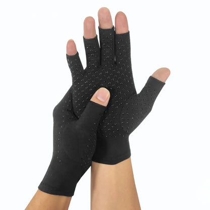 A pair of gray magnetic compression therapy gloves with an open-fingertip design, shown being worn by a person. The gloves appear to be made of a breathable fabric and are designed to provide joint support and pain relief.