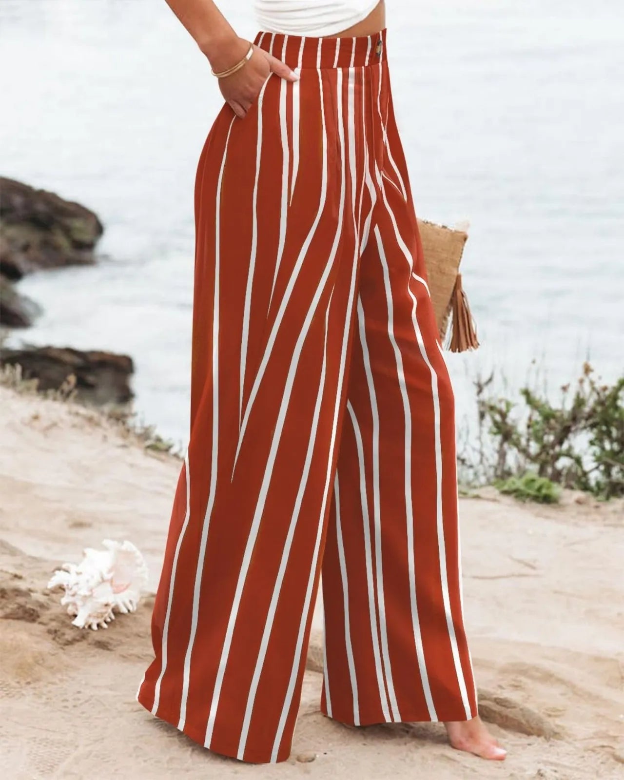 Person wearing red and white striped pants on a beach.