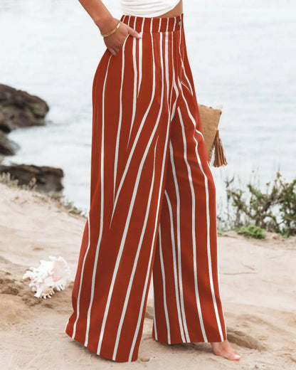 Person wearing red and white striped pants on a beach.